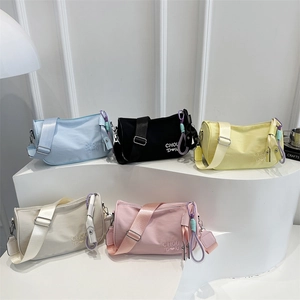 Minimalist nylon cylindrical shoulder bags in five colors with embroidery and wide straps