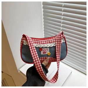 Close-up of retro denim handbag with red gingham trim and sweet lace lace detailing