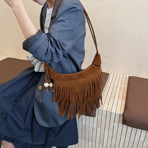 Dettaglio della borsa hobo in pelle scamosciata marrone con frange e perline in legno