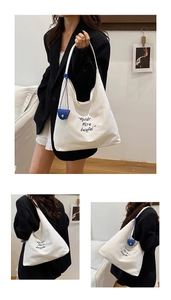Collage of model wearing a large cream canvas hobo bag with blue leather charm detail