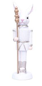 Detail of white rabbit nutcracker soldier figurine with gold scepter and textured uniform