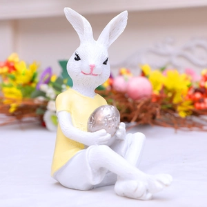 Cute resin Easter bunny figurine in yellow shirt holding a textured silver egg ornament
