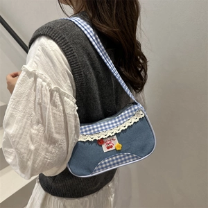 Blue denim and gingham shoulder bag with lace trim and cute cherry patch on a model
