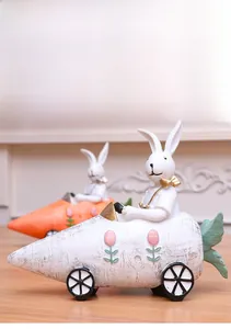 Detail of resin Easter bunny figurines riding carrot cars for tabletop home decoration