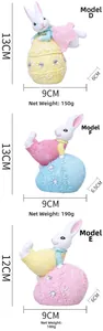 Detail of resin Easter bunny figurines on pastel eggs with lace relief and rhinestones