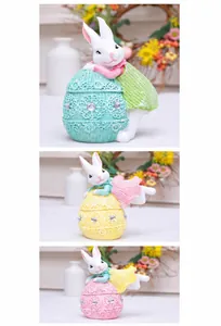 Close-up of resin Easter bunnies in knit-texture outfits holding lace-edged eggs