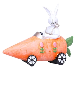 Detail view of a resin Easter bunny driving a carrot car with small black wheels