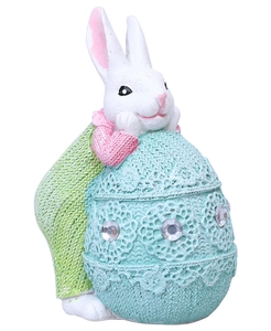 Detalle del conejo de Pascua de resina con huevo texturizado y falsos diamantes