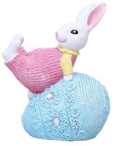 Detalle de conejo de Pascua de resina con textura de punto y huevo azul decorado