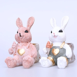 Figuras de conejito de Pascua en rosa y blanco con corazones dorados para decoración de mesa