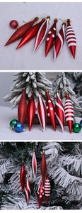 Red and white teardrop Christmas ornaments featuring glitter patterns on a pine tree