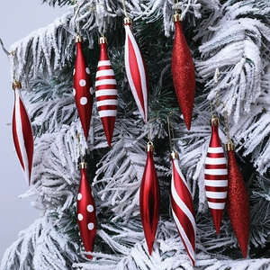 Detail view of red and white striped Christmas tree hanging ornaments on snowy branches