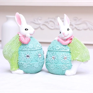 Pareja de conejos de Pascua de resina en huevos verde menta con detalles de encaje