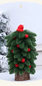 Détail d'un mini sapin de Noël avec bonnet rouge en tricot et base en bois naturel décor