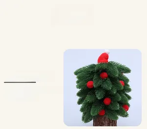 Détail d'un mini sapin de Noël avec bonnet rouge tricoté et socle en écorce naturelle