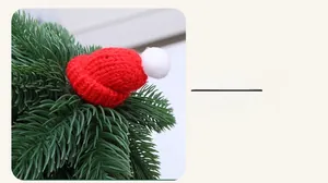Détail d'un mini bonnet de Noël tricoté rouge avec pompon pour décoration de fête