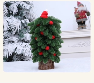 Détail d'un mini sapin de Noël avec pompons rouges et base en bois rustique