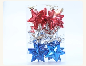 Close-up of star-shaped Christmas ornaments in red, blue and silver with gold cords