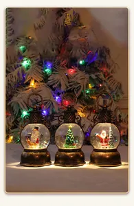 Détail de trois lanternes de Noël vintage en bronze avec lumières LED et boules à neige