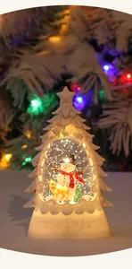 Close-up of lighted Christmas tree water lantern with snowman and reindeer interior