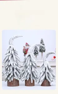 Détail de mini sapins de Noël enneigés avec cime courbée et socles en bois naturel