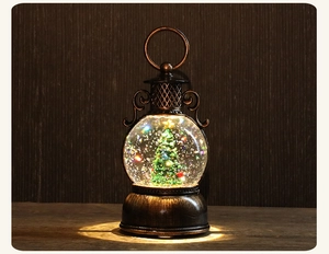 Détail d'une lanterne boule de neige de Noël avec mini sapin et lumière festive chaude