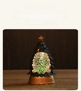 Illuminated Christmas tree water lantern with gold base and swirling glitter detail