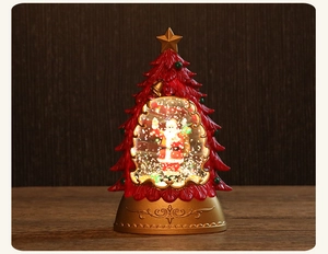 Close-up of a festive Christmas tree snow globe with Santa Claus and golden ornate base