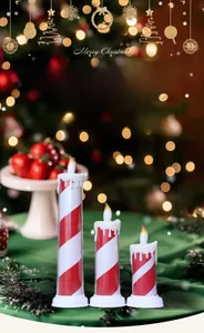 Three red and white striped LED Christmas pillar candles against a festive blurred backdrop