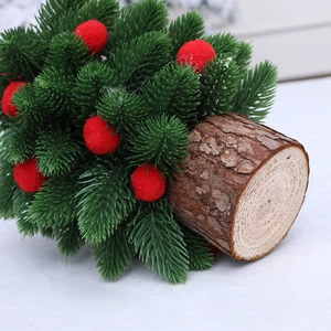Mini sapin de Noël avec pompons rouges sur un socle en bois rond naturel