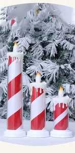 Close-up of three LED Christmas candle lights with red white stripes and snow melt effect