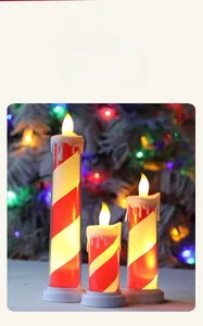 Macro shot of three LED flameless taper candles with red spiral stripes and melting wax effect