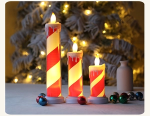 Three LED Christmas candle lights with red white stripes and warm glowing flames