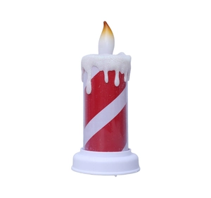 Detail view of red and white striped LED candle with sparkling glitter drip and warm light
