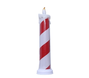 Macro detail of red and white striped LED Christmas candle with realistic dripping wax effect