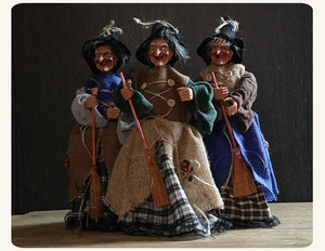 Detalle de tres muñecas de brujas de Halloween hechas a mano con escobas y ropa de tela rústica