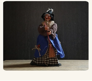 Vista de detalle de muñeca de bruja de Halloween con falda de arpillera y escoba de madera