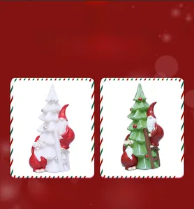 Detail of cute resin Santa Claus climbing a white and green Christmas tree tabletop decor