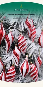 Detail von rot-weißen Spiral-Weihnachtskugeln, die an einer verschneiten Tanne hängen