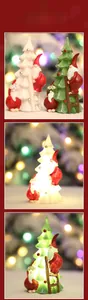 Close-up of glowing resin Santa climbing tree ornaments with LED lights on a table