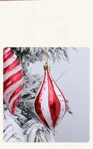 Detailaufnahme rot-weißer Weihnachtsanhänger mit Sternmuster auf verschneiten Zweigen