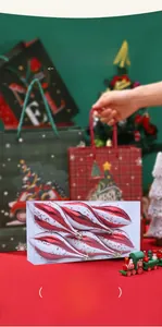 Detailansicht rot-weißer Spiral-Weihnachtskugeln mit goldenen Sternen-Pailletten