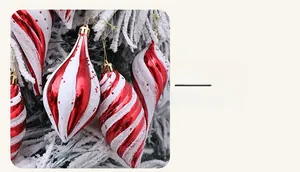 Detail eines rot-weiß spiraligen Christbaumschmucks in Tropfenform mit Glitzer und Sternen