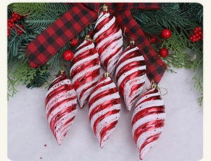 Details von rot-weißen Spiral-Weihnachtskugeln mit Glitzer-Finish auf Kiefernnadeln