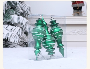 Close-up of green spiral spindle Christmas ornaments with silver glitter in a clear box