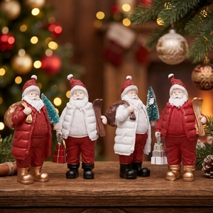 Set of four resin Santa Claus figurines with Christmas trees and gift bags on a wooden table