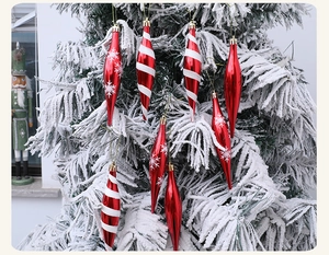 Detalle de adornos de carámbanos rojos y blancos colgados en un árbol de Navidad