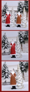 Close-up of resin Santa Claus figurines and snowy white Christmas tree decorations