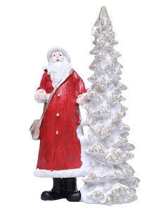 Detailed resin figurines of Santa Claus in red robe beside a glittery white Christmas tree