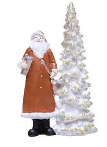 Detail of resin Santa Claus figurine with gift bag and glittering white Christmas tree